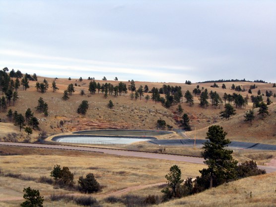 Photograph of existing wastewater treatment lagoons. Three new lagoons will be constructed on the ridge in the background.