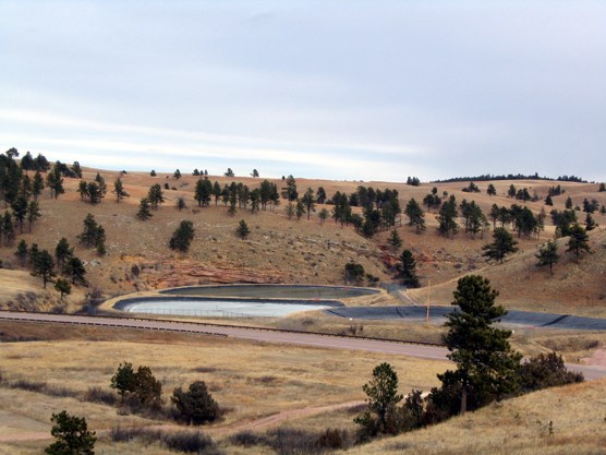Photograph of existing wastewater treatment lagoons. Three new lagoons will be constructed on the ridge in the background.