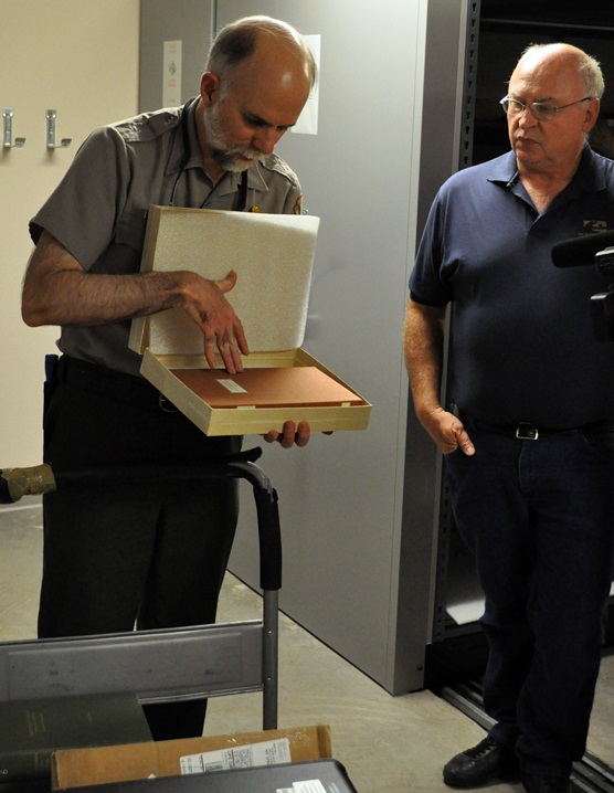 Wind Cave Chief of Interpretation Tom Farrell looks at McDonald Diary container as Joe Joe Muller, Business Manager for the Mammoth Site looks on.