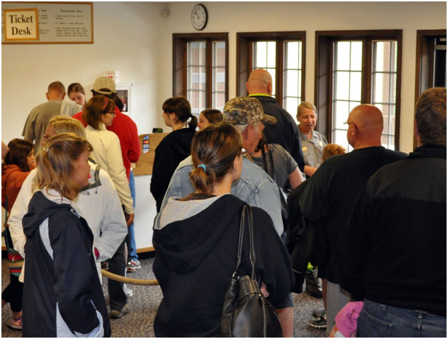 Crowd of visitors waiting in line to purchase tickets inside Wind Cave National Park's visitor center
