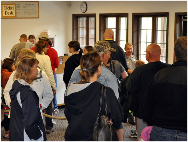 Crowd of visitors waiting in line to purchase tickets inside Wind Cave National Park's visitor center