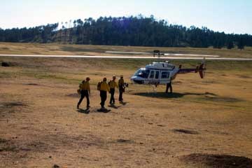 Fire crew members loading onto a helicopter preparing to be delivered to the Curley Canyon Fire.