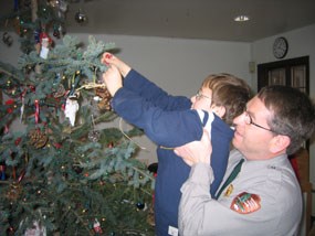 Park Employee Steve Schrempp helps his son Timothy decorate the park’s Christmas tree at last year’s open house. Park Employee Steve Schrempp helps his son Timothy decorate the park’s Christmas tree at last year’s open house.