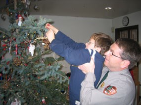 Park Employee Steve Schrempp helps his son Timothy decorate the park’s Christmas tree at last year’s open house.