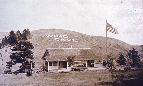 Photograph of the first Wind Cave visitor center and sign on hillside.