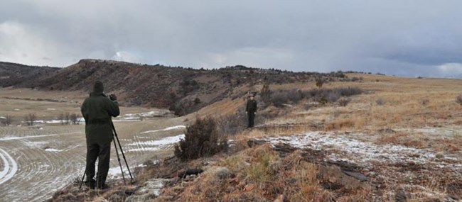 Two rangers filming a video at a buffalo jump site on the Casey property