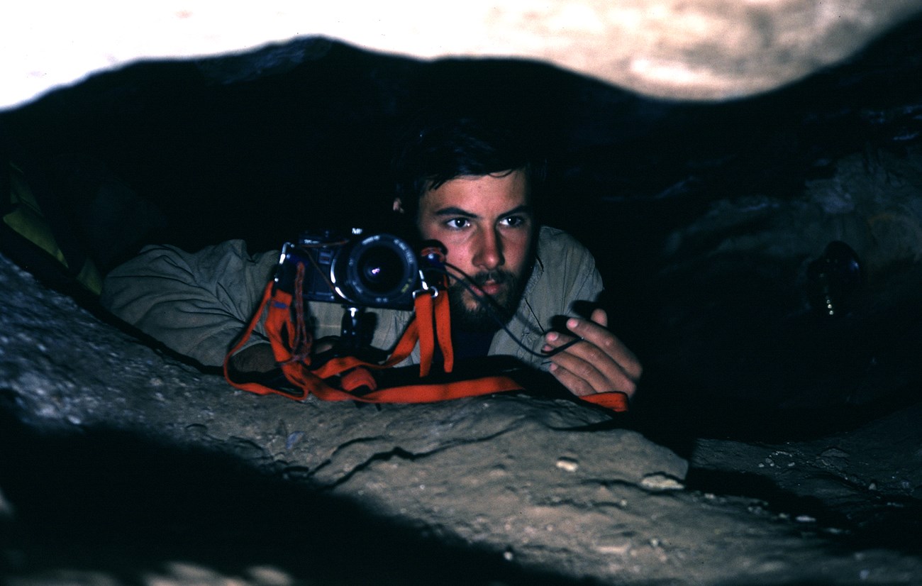 Park employee taking a photograph inside Wind Cave