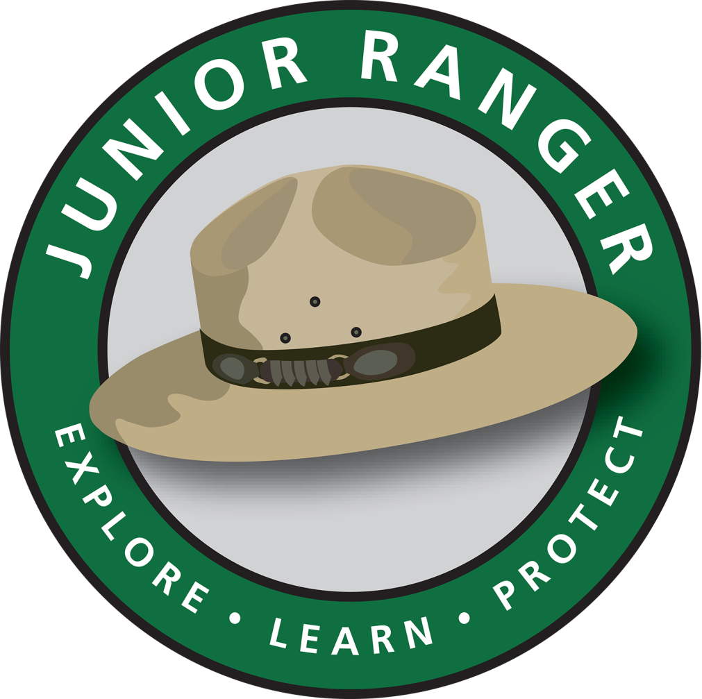 Jr Ranger Logo a green cirle with white lettering that reads Junior Ranger Explore Learn Protect inside the circle is a color drawing of a ranger hat