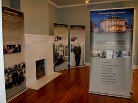 The temporary exhibits at the Clinton Birthplace Home feature freestanding panels with information and photographs about Mr. Clinton's early life in Hope, Arkansas. The temporary exhibits at the Clinton Birthplace Home feature freestanding panels with information and photographs about Mr. Clinton's early life in Hope, Arkansas.