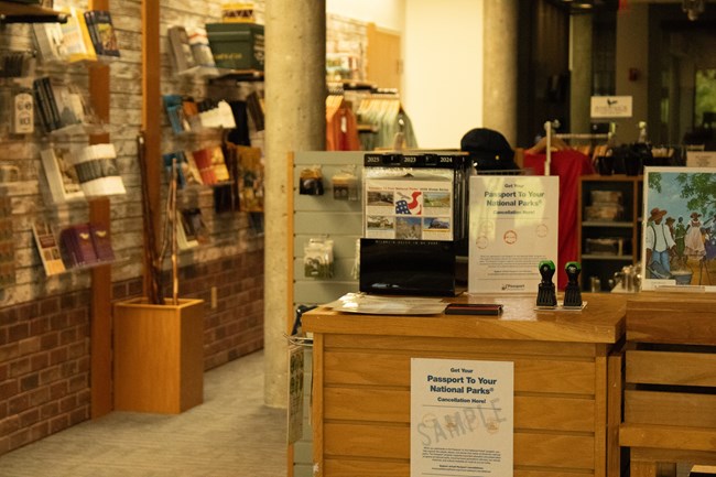A wooden stand with stickers, an orange open stamp pad, and several stamps in a gift shop.