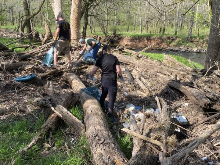 A crew of volunteers removes garbage and debris from Wilson's Creek at Wilson's Creek National Battlefield.