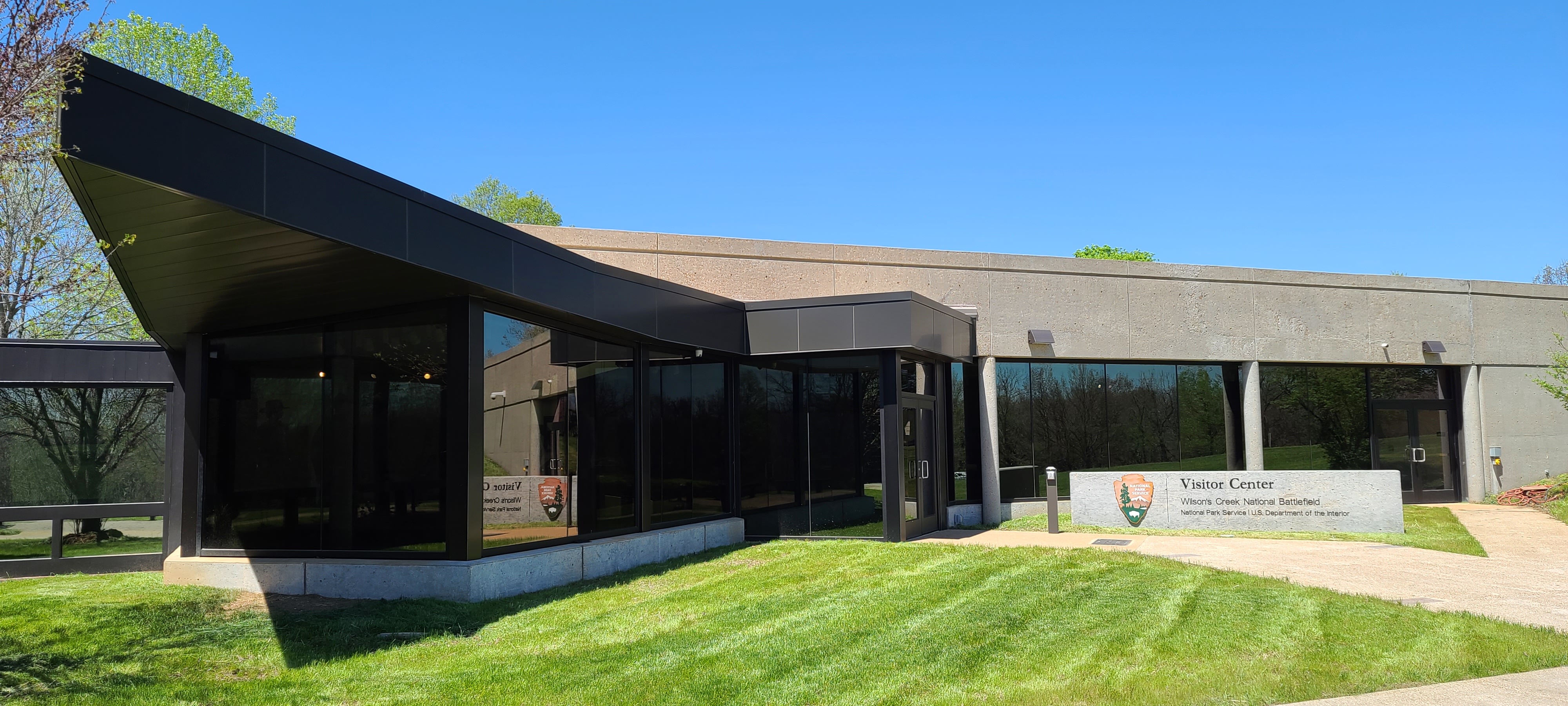 Front of the visitor center is angular and made of concrete and dark glass.