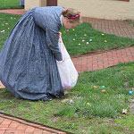 A park Volunteer helps plant Easter eggs near the Taft house for the Easter egg hunt