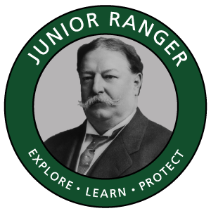 Photo of a man wearing suit and tie and a circle around it with William Howard Taft Junior Explore Learn Protect in text