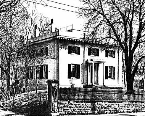 Taft House A large two-story home on a hill surrounded by trees and a wrought iron fence