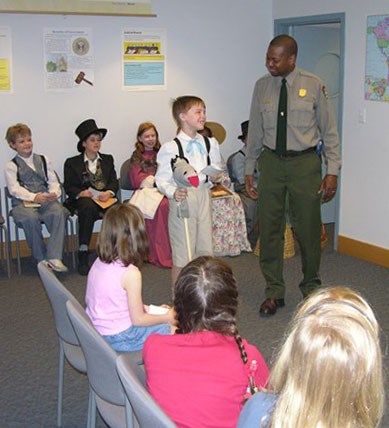 A ranger in a room with several children