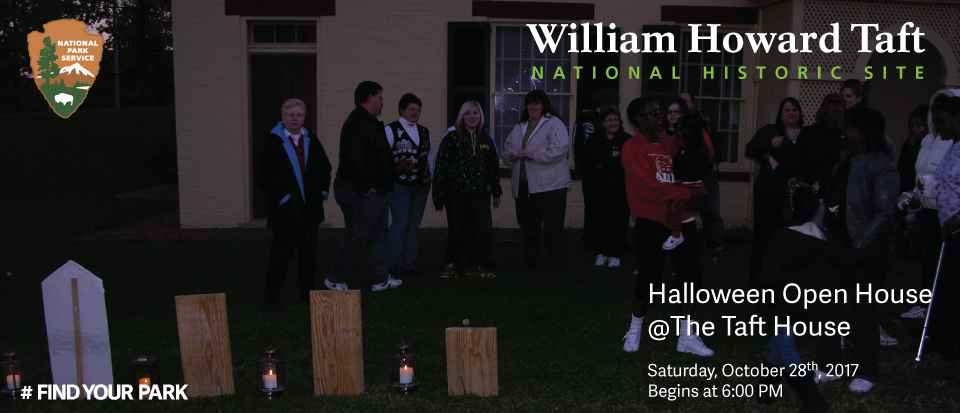 Halloween 2017 A group of people stand between a row of replica headstones and a house