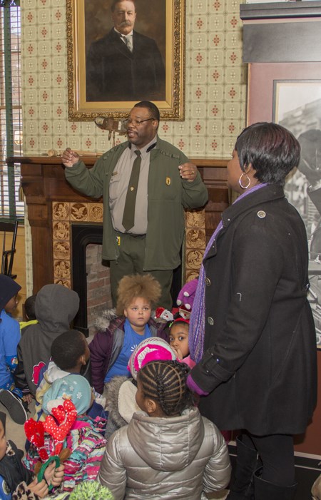 Ranger tour at WIHO A park ranger in a green jacket and green pants speaks to a group of kids and adults