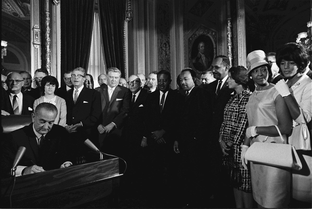 Historical photograph of Lyndon Johnson signing Voting Rights Act.