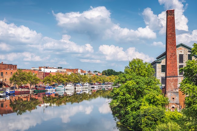 A canal flanked by buildings on a sunny summer day.