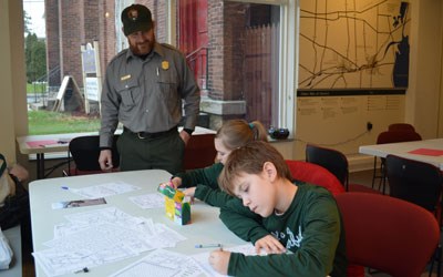 Ranger Bill watches as his children color It's a Wonderful Life scenes in the Children's Craft Corner.