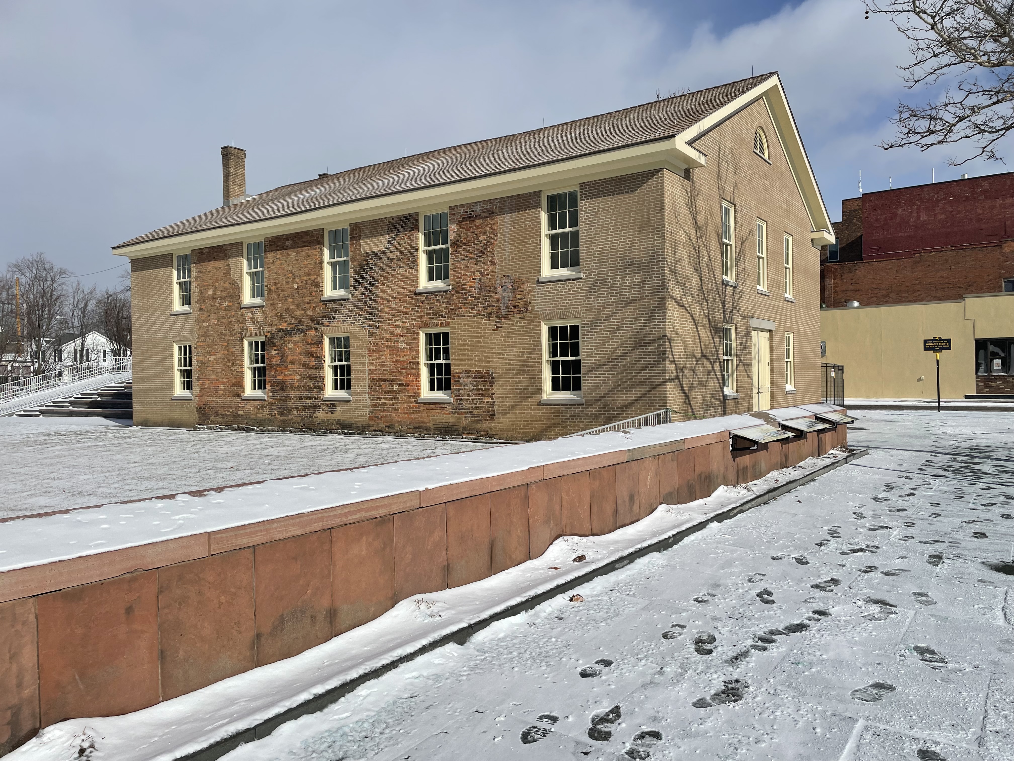 A two story brick building covered in a light layer of snow.