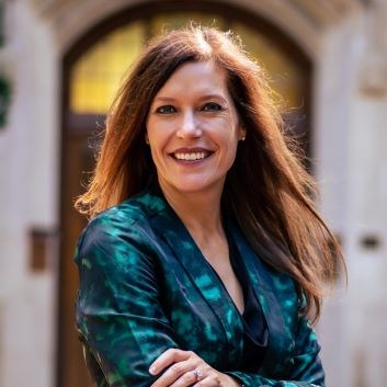 A smiling woman with long red hair.