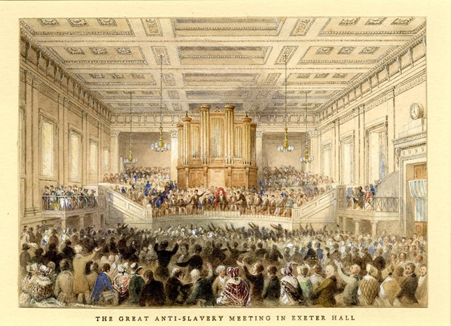 figures on platform with railings across front, figure sitting on raised chair in centre, below crowd of people, most sitting, some with raised arms Watercolour, touched with bodycolour, with some scratching out, over graphite