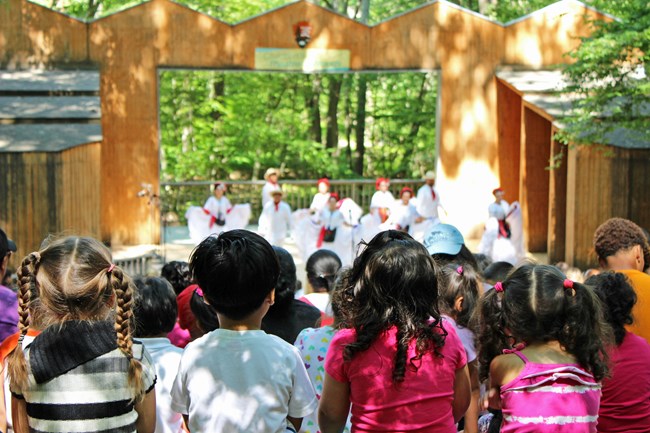 Four kids watch a show at Children's Theatre-in-the-Woods.