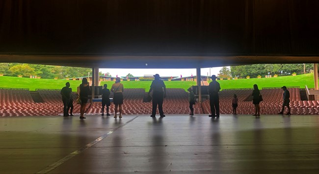 Ranger leads a tour out onto the Filene Center stage.