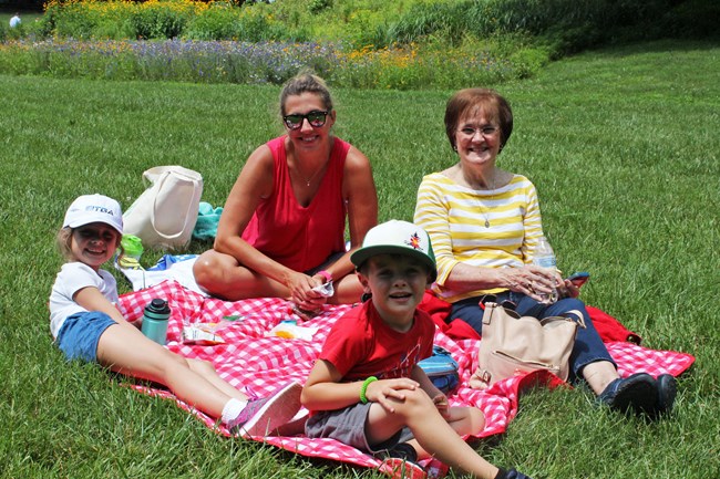 A family picnics in the Meadow after a show.