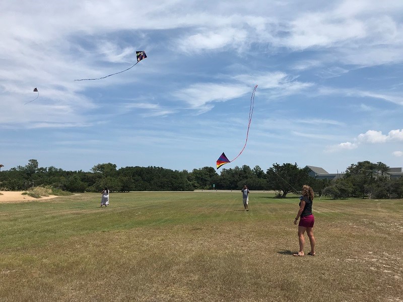 Enjoying the steady wind on a beautiful day at Wright Brothers NMEM Dare County teachers flying kites at Wright Brothers National Memorial.