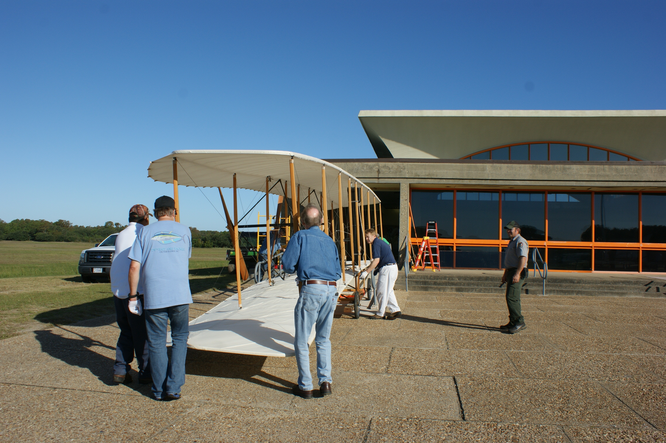 Moving crew carefully moving the Wright brothers 1903 Flyer from the visitor center.