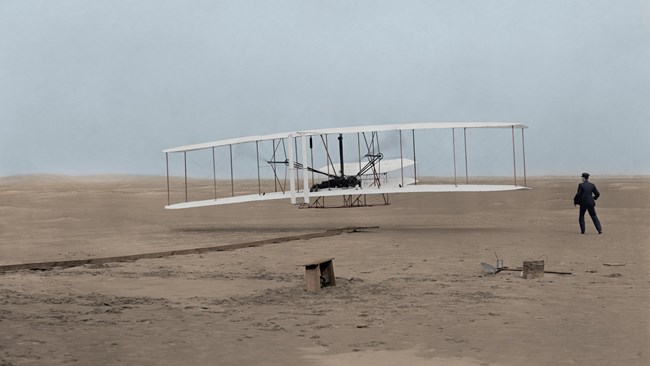 Early bi-plane lifting off the sand