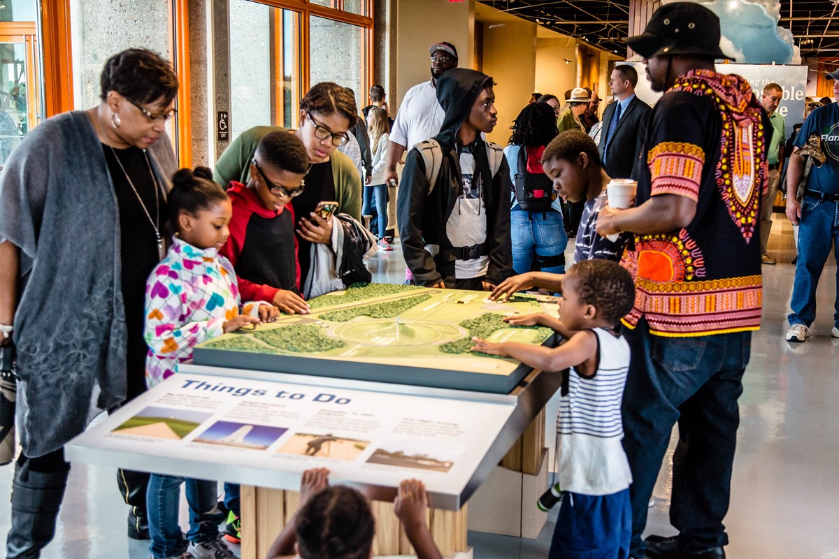 Family looks at tactile map of park inside the visitor center