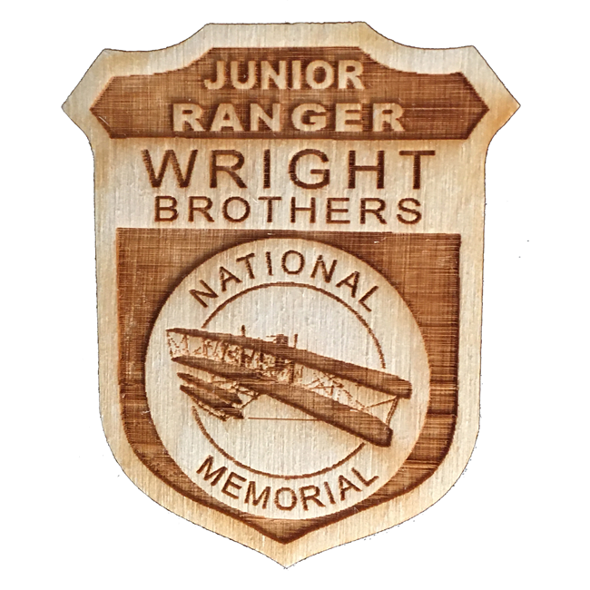 A wooden junior ranger badge for Wright Brothers national memorial