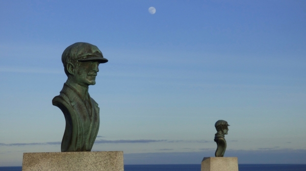 Copper busts of Orville and Wilbur Wright with moon in background.