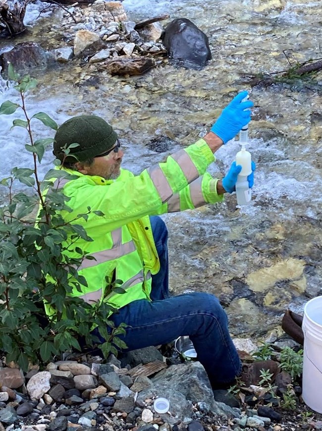 Collecting water samples from National Creek during the Remedial Investigation in 2021