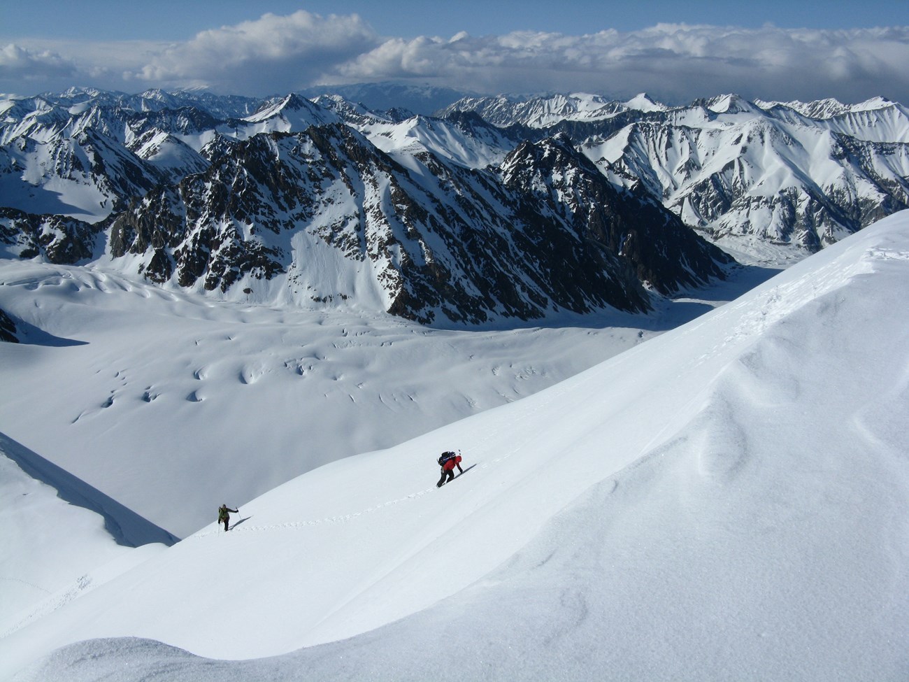 two people traversing the glacier on skiis