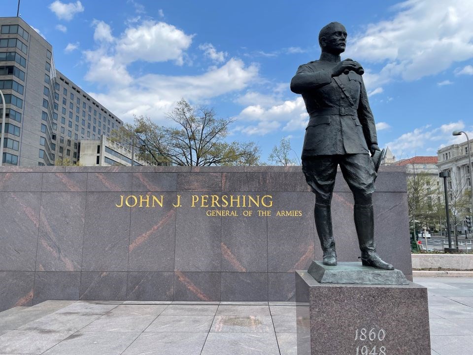 Statue of a man in military uniform holding binoculars