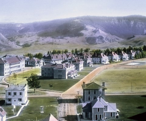A historical photo of buildings surrounded by green lawns