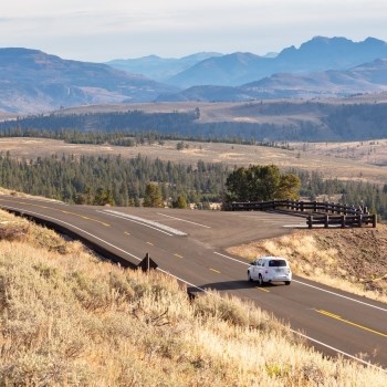 a car driving down a windy, mountainous road