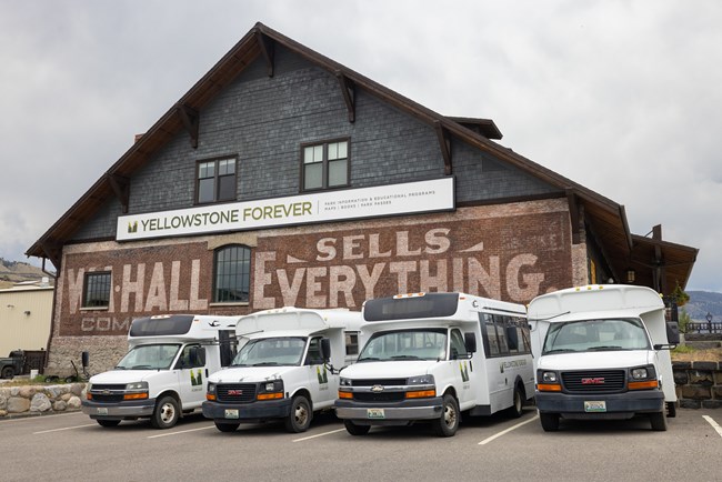 Historic Yellowstone Forever building with tour busses parked out front
