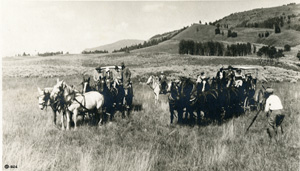 YELL 127706 is a view of two 4- horse carriages loaded with passengers, 1926, probably the Lamar Valley. There is a man with a tripod and camera. It is possible this is the filming of “The Thundering Herd.”