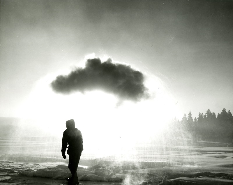 Black-and-white photo of a small cloud raining on a man