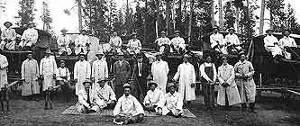 Group portrait of stagecoach drivers working for Yellowstone Western Stage Company, wearing dusters, circa 1914.