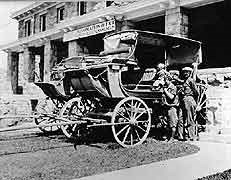 (YELL 109809) A 1926 image of three visitors from Salt Lake City posed with two stagecoaches on the lawn of the Albright Visitor Center. The coach in the foreground is the Yellowstone Observation Wagon