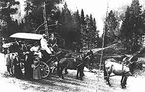 (YELL 36451) Driver and passengers posed with a four-horse Yellowstone Observation Wagon similar to the vehicle in the park's museum collection.