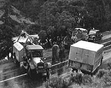(YELL 27053-1) Accident scene in Gardner Canyon, 1952. The vehicle at left is Yellowstone Park Transportation Company Service Truck #937, and was used to help recover a car that had plunged into the river.