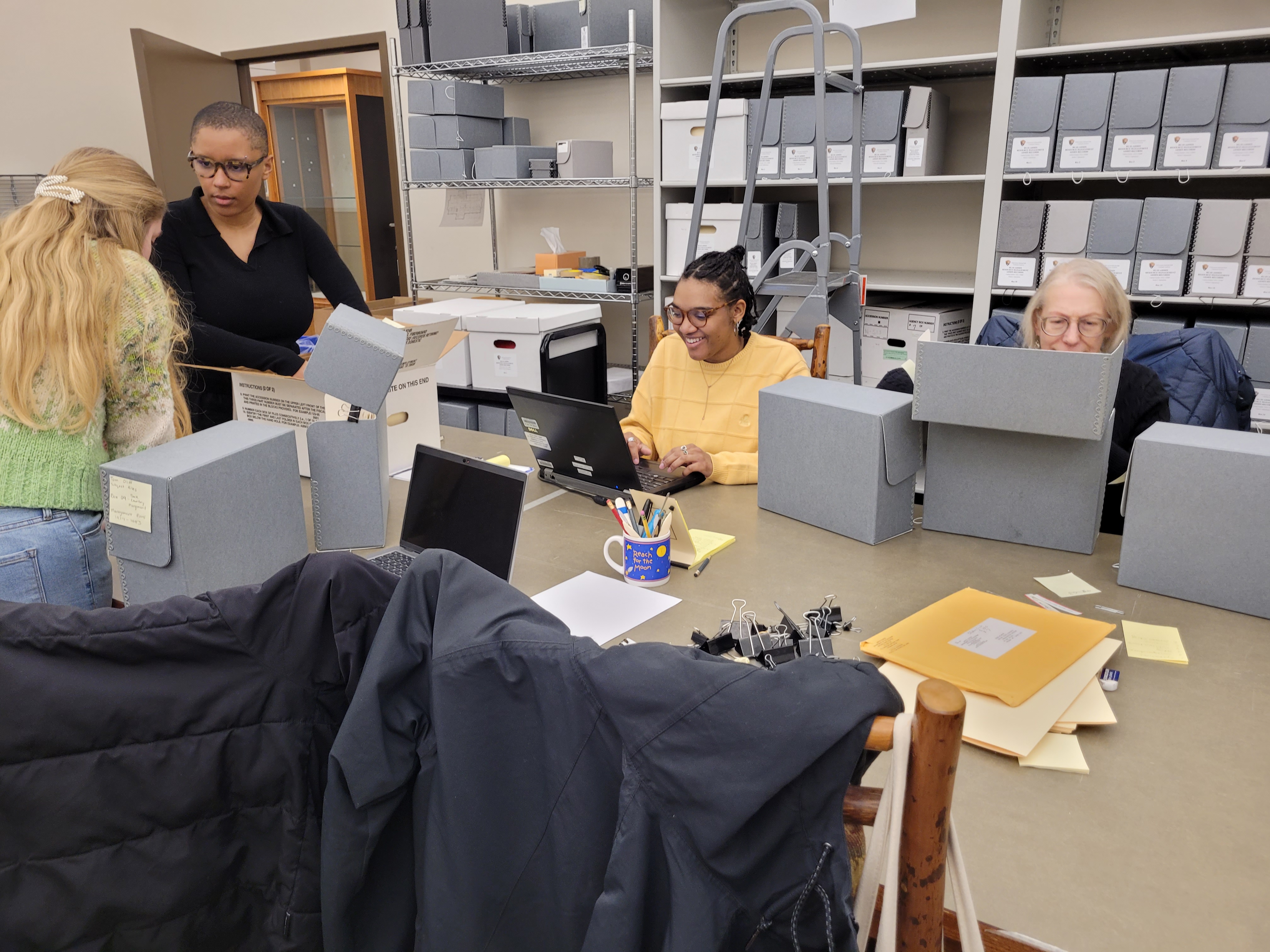 Several people working through a backlog of archival materials in a park library